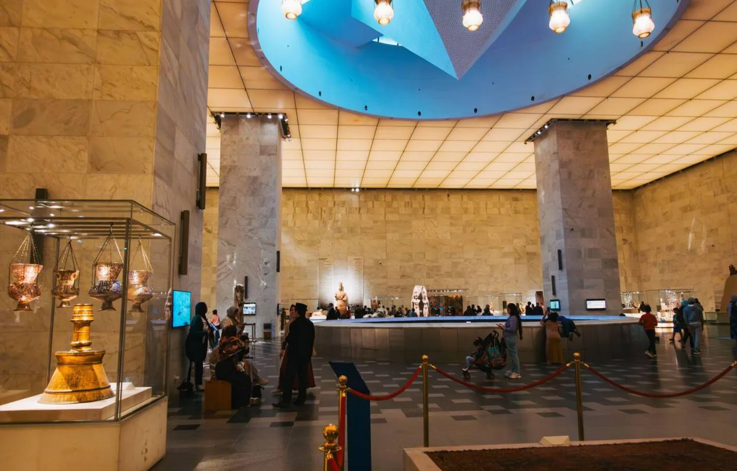 Visitors enjoying a layover excursion in Cairo while exploring the main hall of the National Museum of Egyptian Civilization