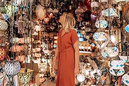 A tourist exploring vibrant glass lanterns during a Khan El Khalili bazaar excursion in the heart of Old Cairo