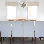 Elegant indoor dining area with a long table and white upholstered chairs