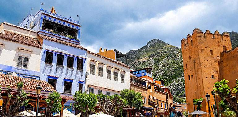 Lively street scene in the medina of Chefchaouen Morocco with blue painted buildings the historic Kasbah tower