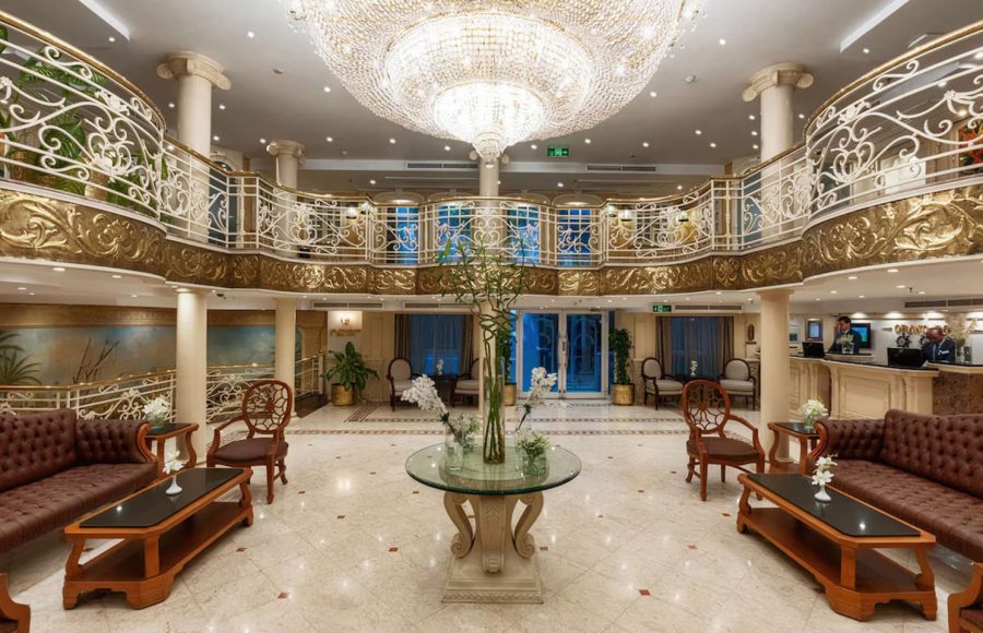 Indoor lounge area with leather seating and a view of the Nile through a window.