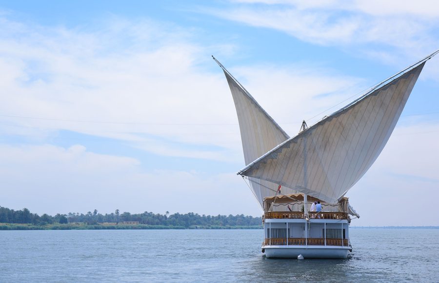 Rear view of the Loulia Dahabiya sailing on the Nile under a blue sky.