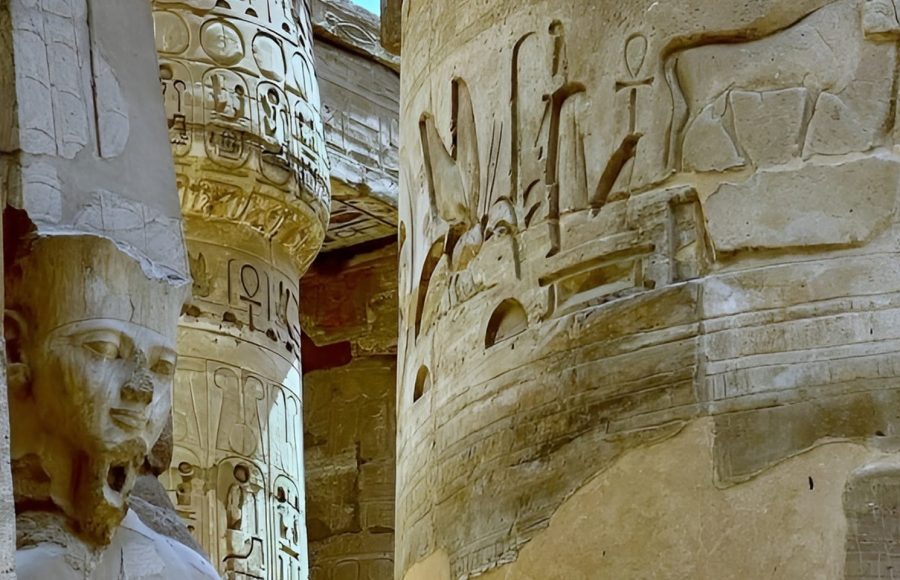 Ancient Egyptian columns and statues with hieroglyphs.