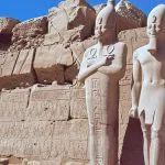 Interior view of a vividly painted Egyptian tomb chamber with figures and hieroglyphs