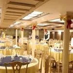 Formal restaurant with round tables and white-clad staff.