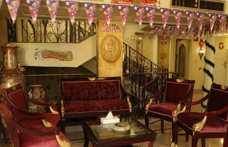 Ship lobby with red velvet chairs and holiday decorations.