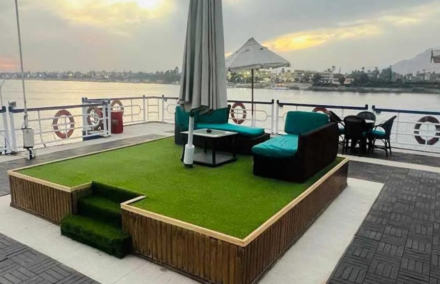 A raised green platform with outdoor sofas on the deck.