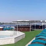 Panoramic view of the sundeck with pool, bar, and loungers.