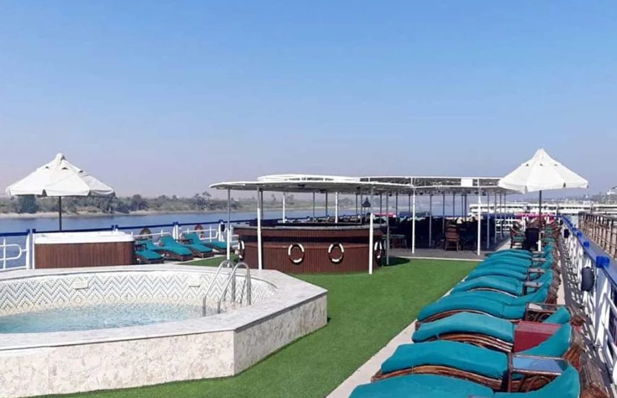 Panoramic view of the sundeck with pool, bar, and loungers.
