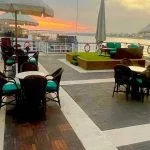 Outdoor seating area on the cruise deck at sunset.