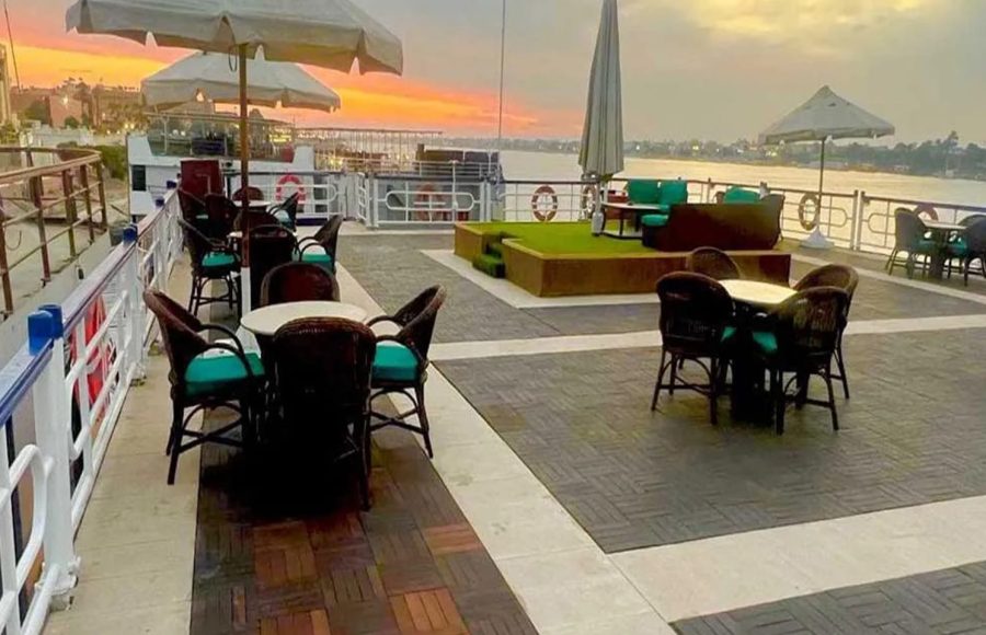 Outdoor seating area on the cruise deck at sunset.