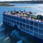 High-angle view of the MS Al Nabilatan cruise ship showing the full sun deck layout and the Nile River.