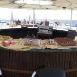 A circular outdoor bar displaying various cakes and desserts.