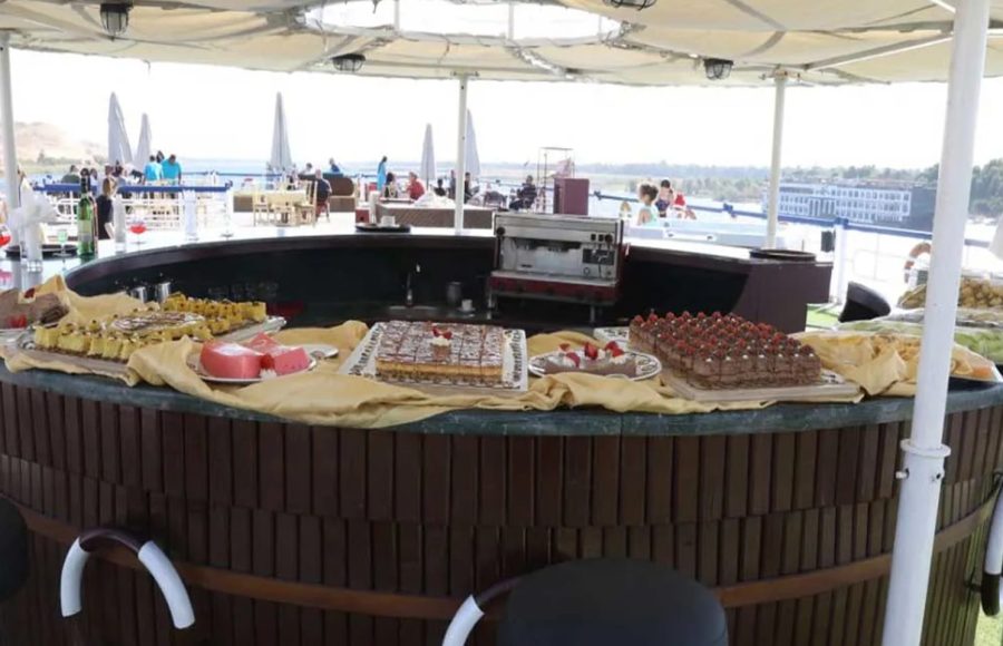A circular outdoor bar displaying various cakes and desserts.
