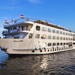 Large white MS Al Hambra cruise ship sailing on the Nile River under a clear blue sky.