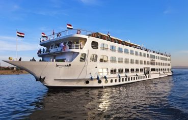 Large white MS Al Hambra cruise ship sailing on the Nile River under a clear blue sky.