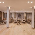The elegant and spacious lobby of the MS Alma Nile Cruise, featuring polished marble floors, comfortable seating areas, warm recessed lighting, and decorative potted plants.