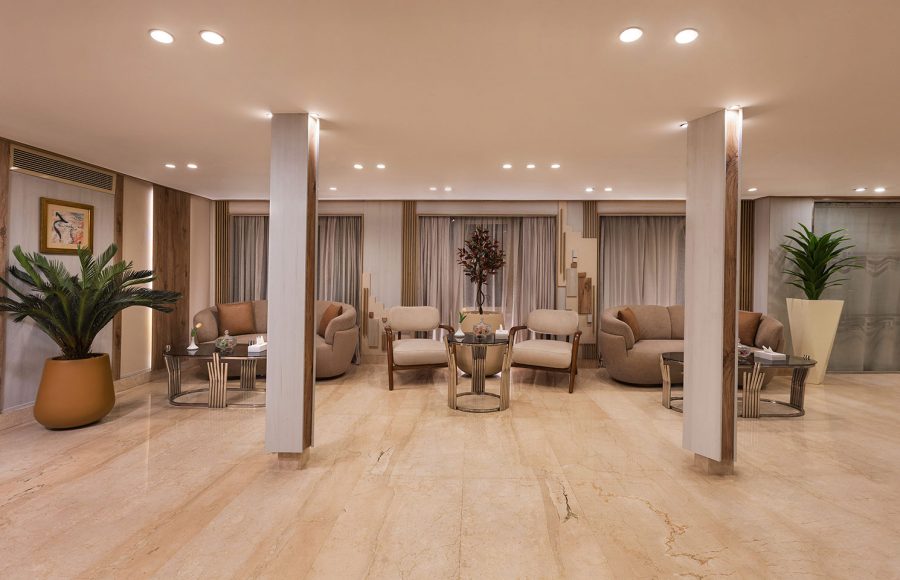 The elegant and spacious lobby of the MS Alma Nile Cruise, featuring polished marble floors, comfortable seating areas, warm recessed lighting, and decorative potted plants.