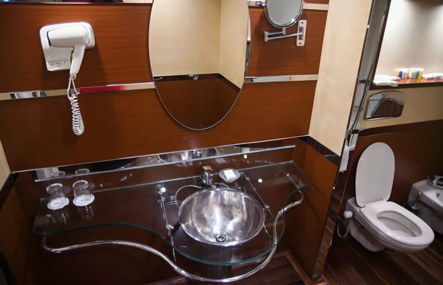 Modern bathroom with wood paneling and a glass vanity.