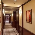 Interior hallway of the cruise ship with wood trim and art.