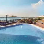 An outdoor swimming pool on a ship's sun deck overlooking the Nile River.