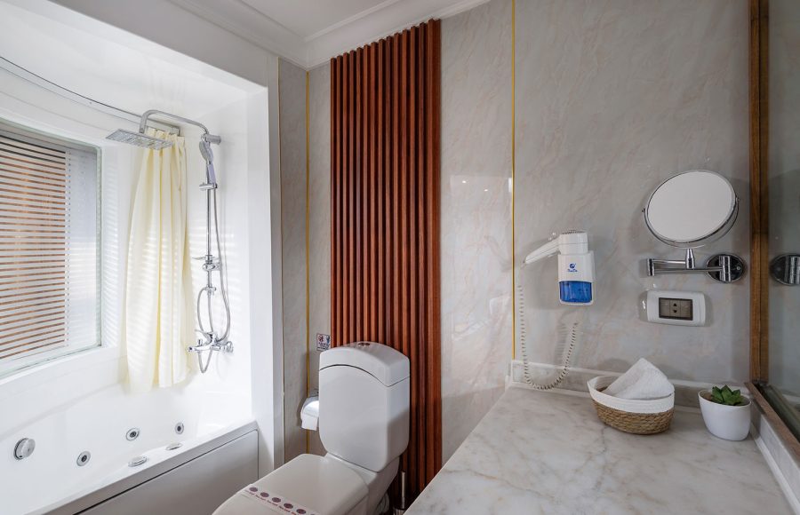 A modern and luxurious bathroom aboard the MS Chateau Lafayette Nile Cruise, featuring a bathtub with a shower, a sleek vanity, and high-end fixtures.