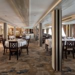 The elegant dinning room aboard the MS Chateau Lafayette Nile Cruise, featuring neatly set tables, comfortable wooden chairs, and soft interior lighting.