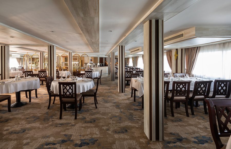 The elegant dinning room aboard the MS Chateau Lafayette Nile Cruise, featuring neatly set tables, comfortable wooden chairs, and soft interior lighting.