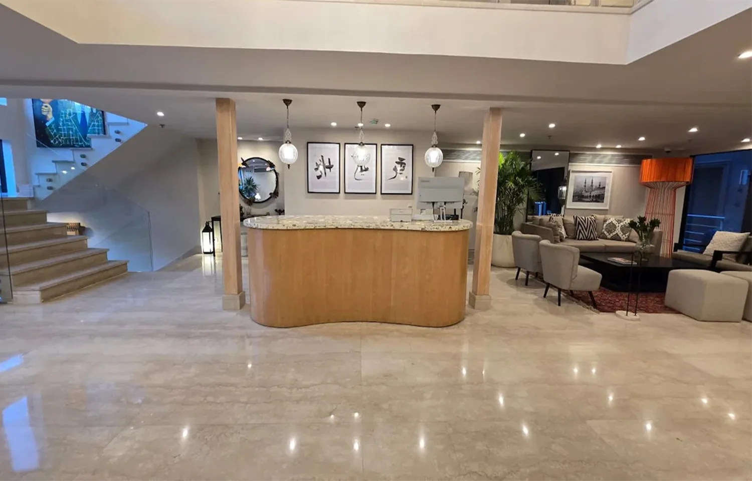 The modern reception area of the MS Ellie Nile Cruise with a light wood desk, marble floors, and a seating area nearby.