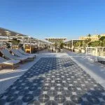 Sundeck of the MS Ellie Nile Cruise with rows of lounge chairs and patterned blue and white tile flooring under a blue sky.