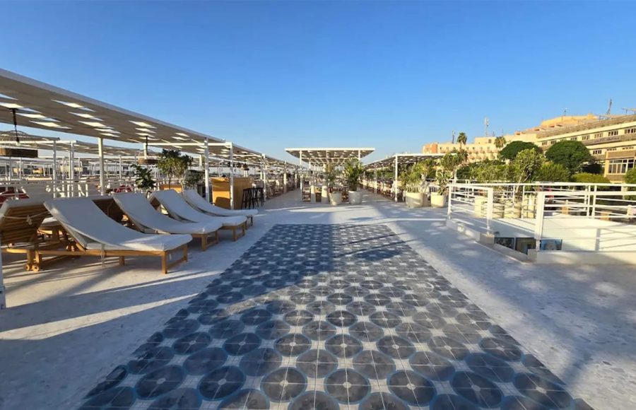 Sundeck of the MS Ellie Nile Cruise with rows of lounge chairs and patterned blue and white tile flooring under a blue sky.