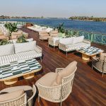 Comfortable outdoor seating and sofas on the Sun Deck of the MS Esmeralda Nile Cruise, overlooking the scenic Nile River.