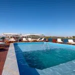 The sparkling swimming pool and sun deck on the La Traviata Nile Cruise under a clear blue sky.