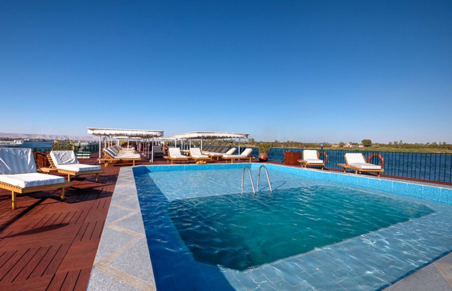 The sparkling swimming pool and sun deck on the La Traviata Nile Cruise under a clear blue sky.