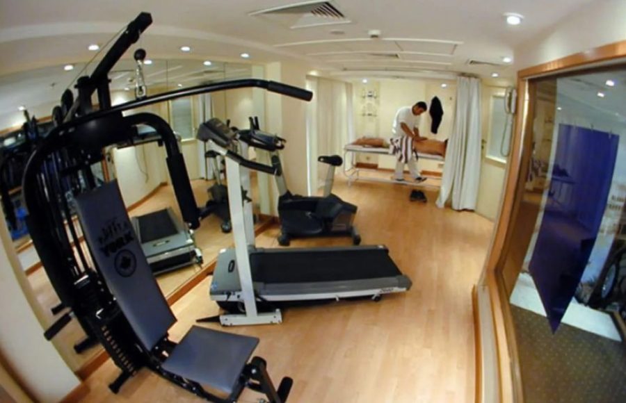 Ship gym with exercise equipment and an adjacent massage area.