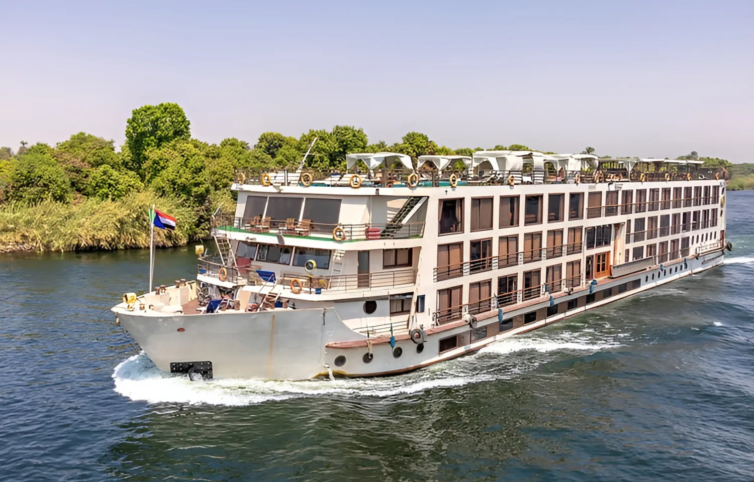 Four-deck MS Dolphin Nile cruise ship sailing on the Nile River.