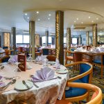 A spacious and elegant Dinning Room aboard the MS Nile Treasure Cruise, featuring beautifully set tables with crisp linens, warm lighting, and stylish chairs.