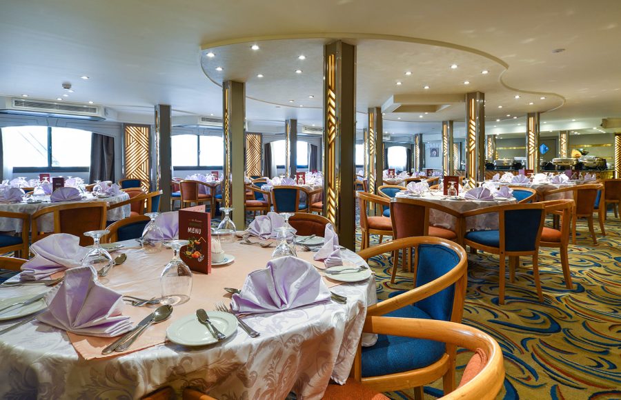 A spacious and elegant Dinning Room aboard the MS Nile Treasure Cruise, featuring beautifully set tables with crisp linens, warm lighting, and stylish chairs.
