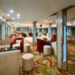 The elegant and welcoming reception lounge area on the MS Nile Treasure Cruise, featuring contemporary seating, patterned carpeting, and warm ambient lighting.