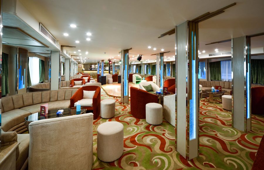 The elegant and welcoming reception lounge area on the MS Nile Treasure Cruise, featuring contemporary seating, patterned carpeting, and warm ambient lighting.