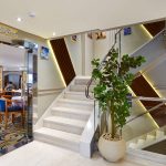 The entrance to the main restaurant aboard the MS Nile Treasure Cruise, featuring a bright modern staircase, sleek glass doors, and a welcoming interior view.
