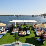 Guests relaxing on the sun deck of the MS Nile Treasure Cruise, featuring lounge chairs, sun umbrellas, and panoramic views of the Nile River.