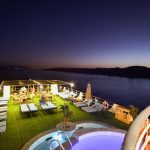 The illuminated sun deck at sunset on the MS Nile Treasure Cruise, featuring lounge chairs, an outdoor pool, and a breathtaking view of the Nile River at dusk.