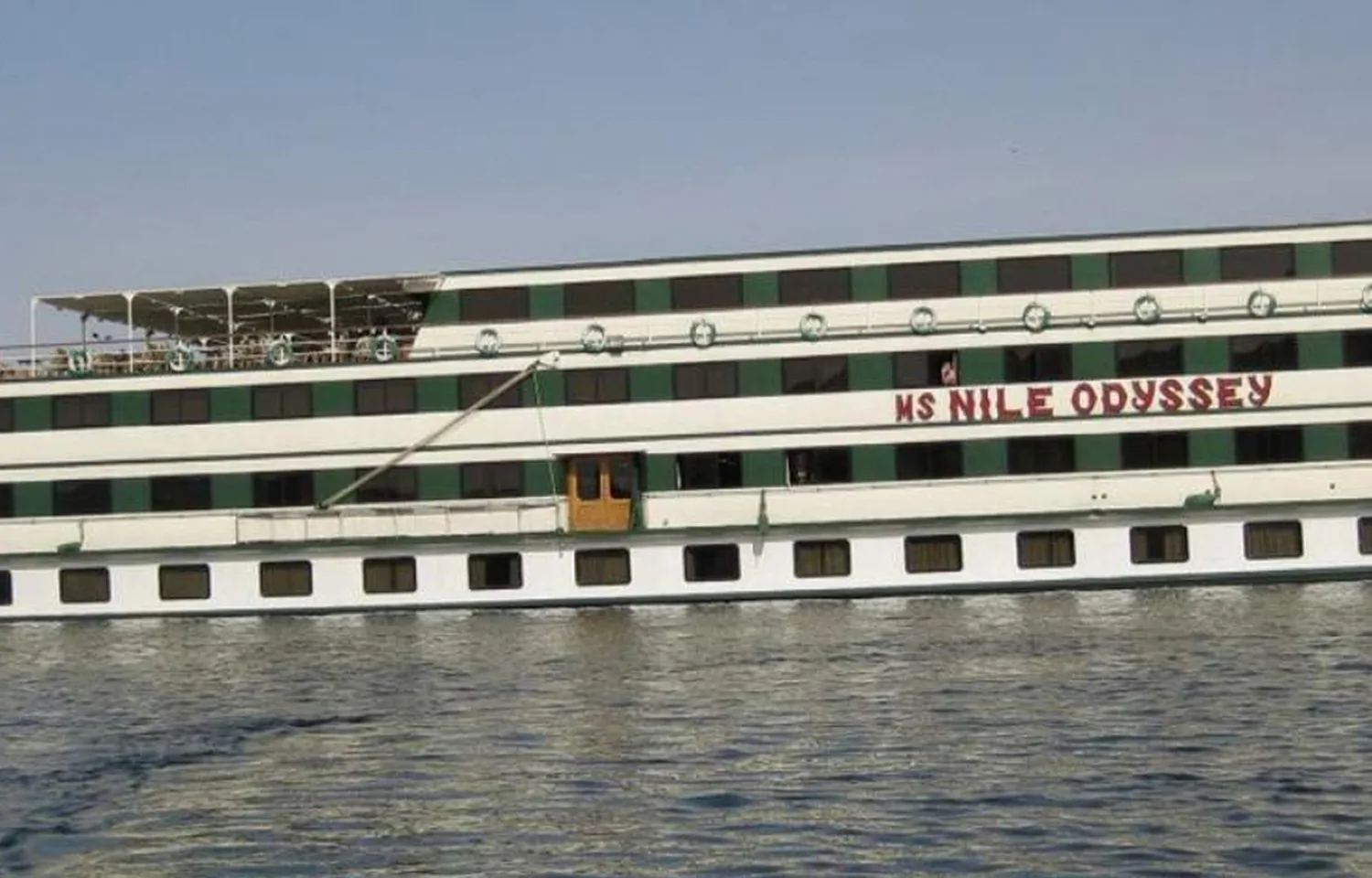 The exterior of a multi-deck white and green cruise ship named 