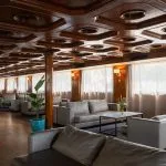 Long, luxurious lounge on the MS Nile Plaza with a high-gloss octagonal coffered wood ceiling, multiple gray leather seating groups, and large windows.