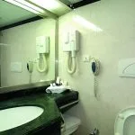 A clean, modern bathroom on the MS Quest Nile Cruise with a green marble vanity and white tiled walls.