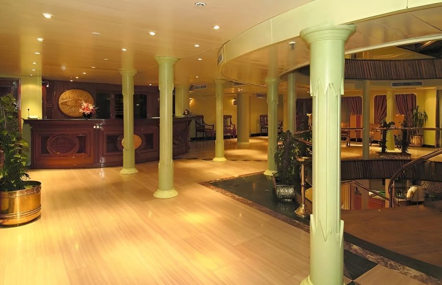 The elegant wooden reception desk and lobby area of the MS Quest Nile Cruise with classic pillars.