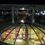 The top deck of the MS Quest at night featuring a glass skylight dome and outdoor seating under a canopy.