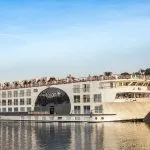 MS Farah Nile cruise ship sailing on the river under a clear blue sky.