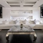 Formal dining room on the MS Farah cruise ship with set tables, white columns, and purple-backed chairs.